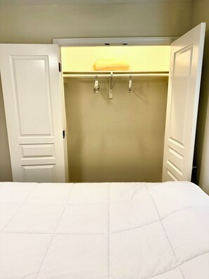 Ein Schlafzimmer mit Bett, Kleiderschrank und Pendelleuchte.