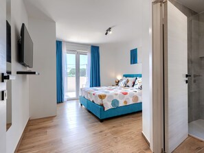 A bedroom with a bed, a television mounted on the wall, and a sliding glass door leading to an outdoor area. - Vacation home LaLuMa by Interhome (Pula)