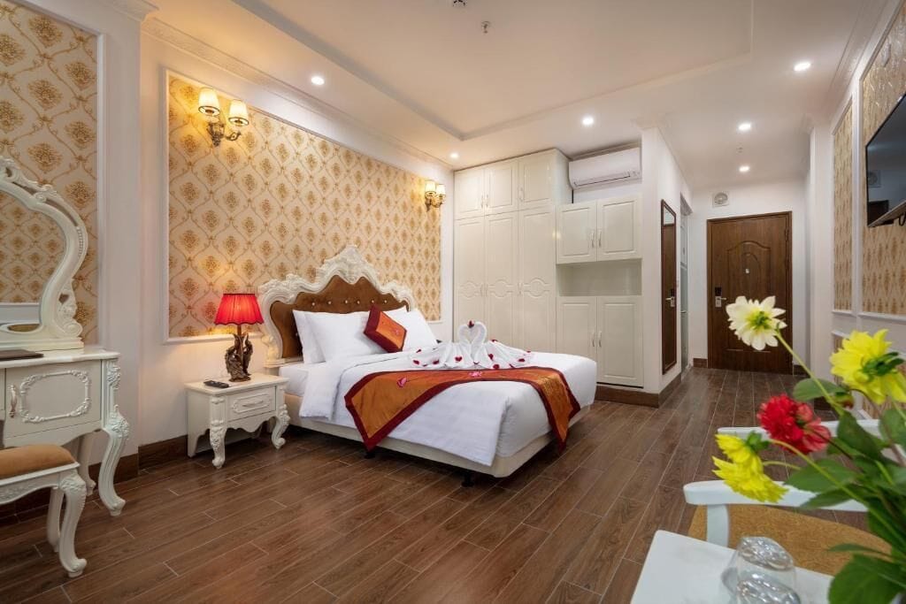 Una habitación de hotel con una cama grande, un armario blanco y un espejo.