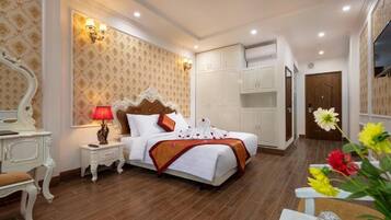 Una habitación de hotel con una cama grande, un armario blanco y un espejo.