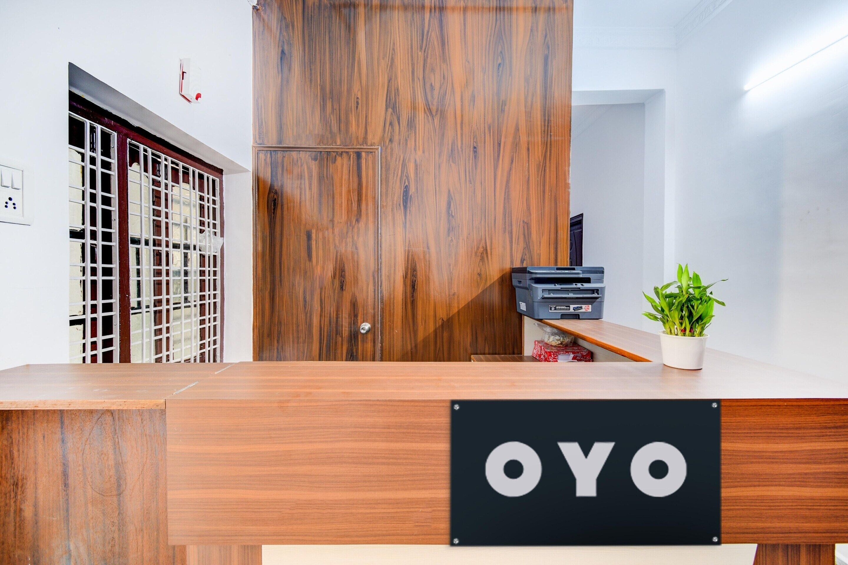 A reception desk with a wooden finish and a sign that reads 'OYO'.