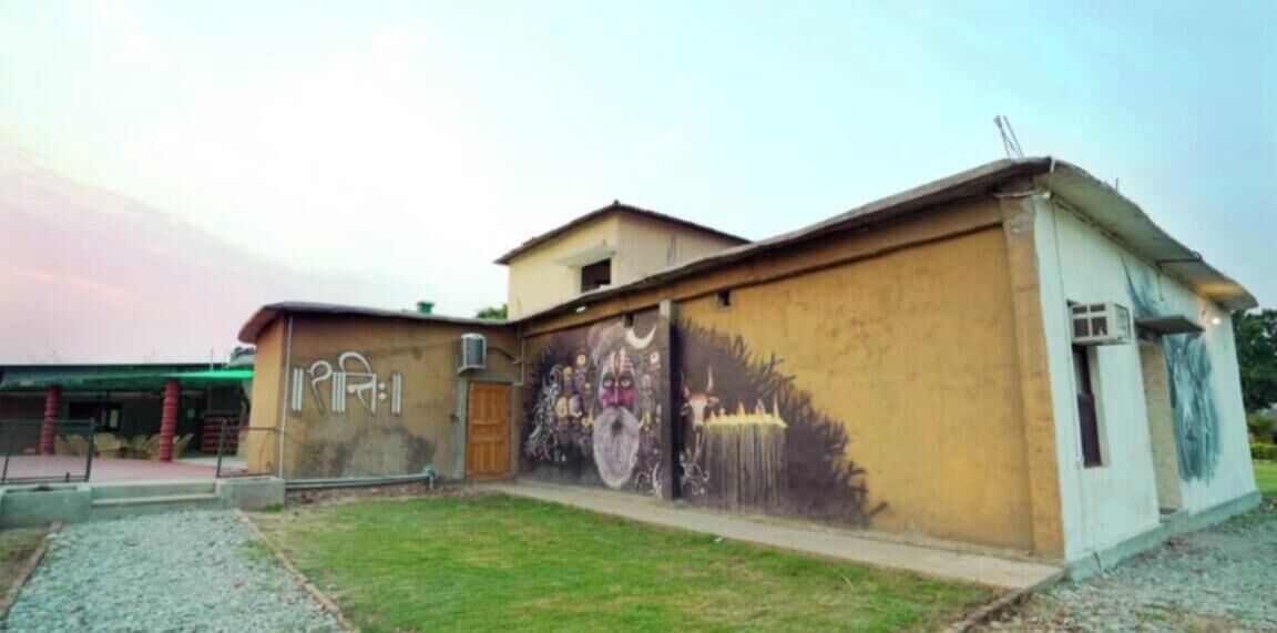 A building with a mural on the side, a door, and a small window.