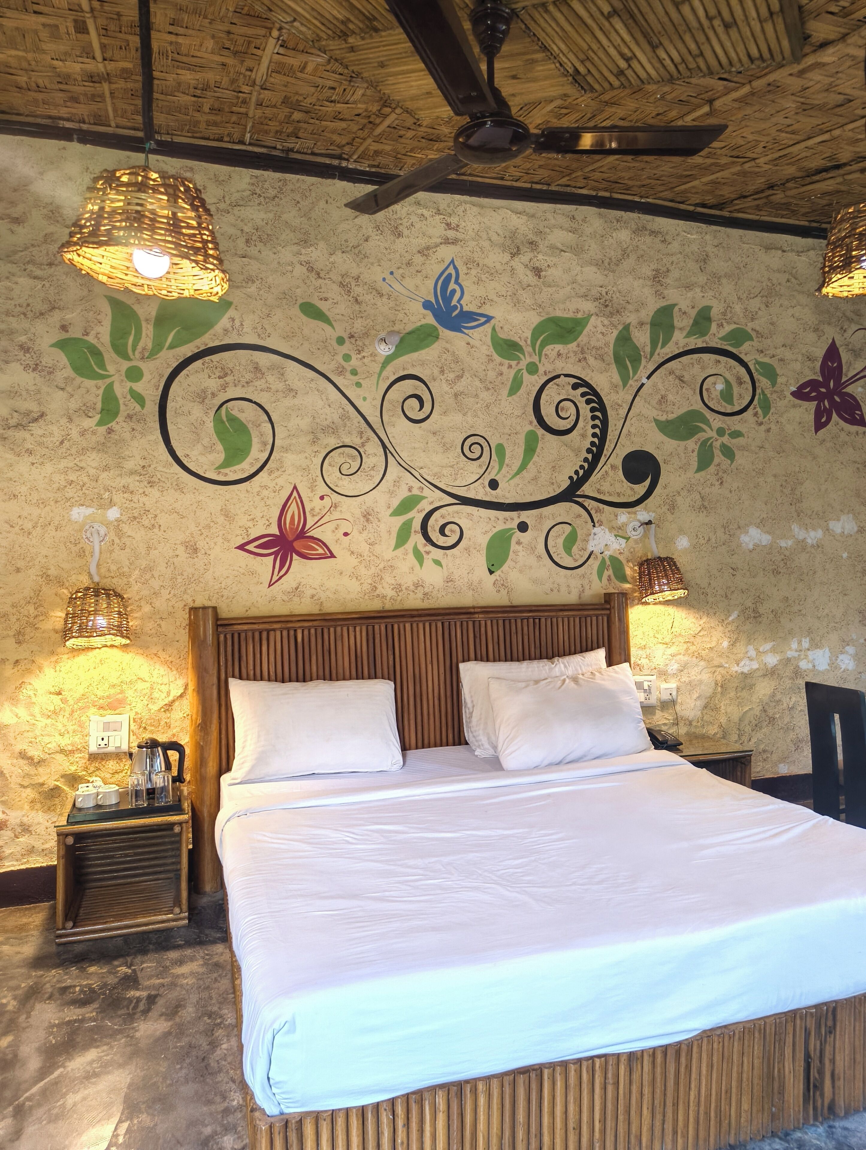 Una habitación con una cama, dos lámparas de pared, un ventilador de techo y decoración en la pared.