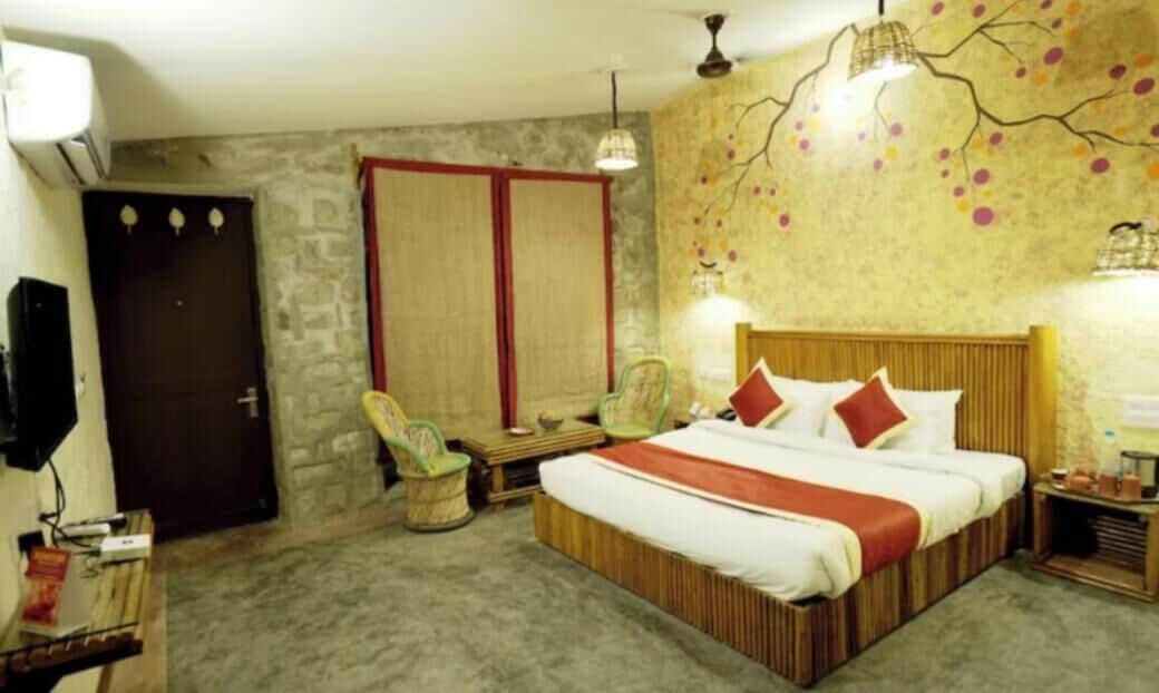 A bedroom with a large bed, a wardrobe, a chair, and a desk.