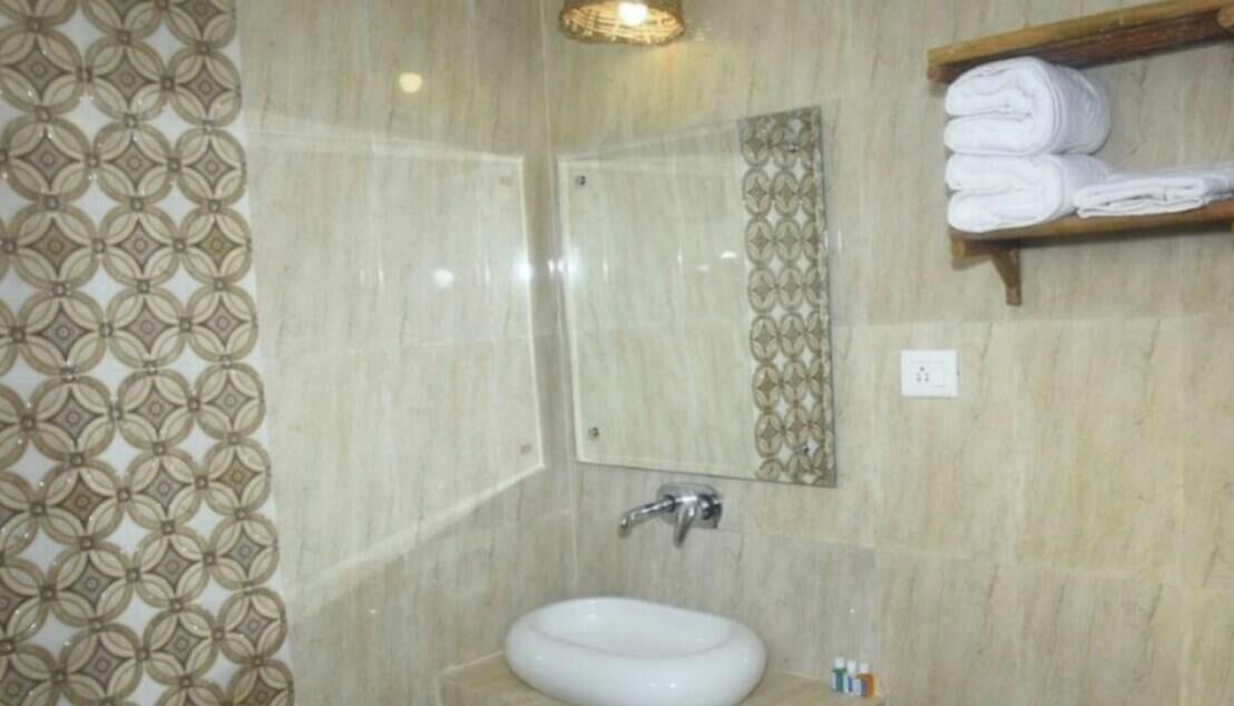 A bathroom with a white sink, a mirror, and a towel rack.