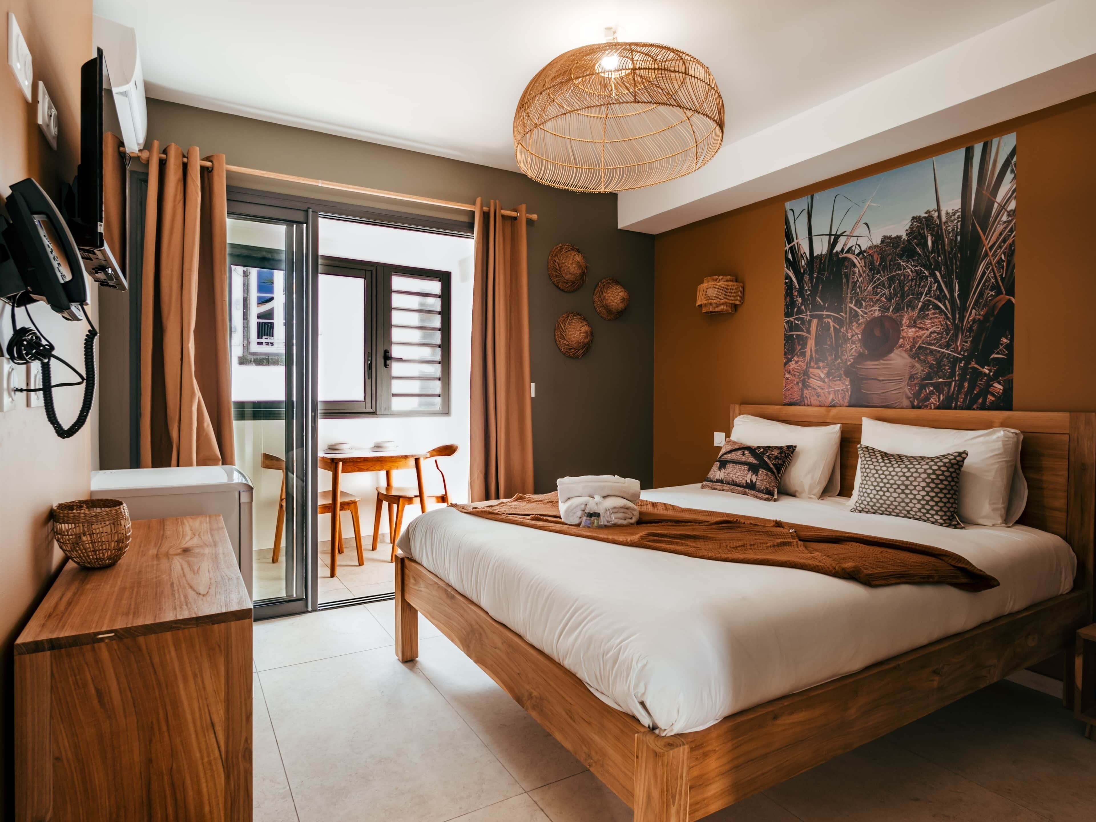 Habitación de hotel moderna con cama, escritorio, silla, mesa, teléfono y un cuadro en la pared.
