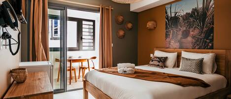 Habitación de hotel moderna con cama, escritorio, silla, mesa, teléfono y un cuadro en la pared.