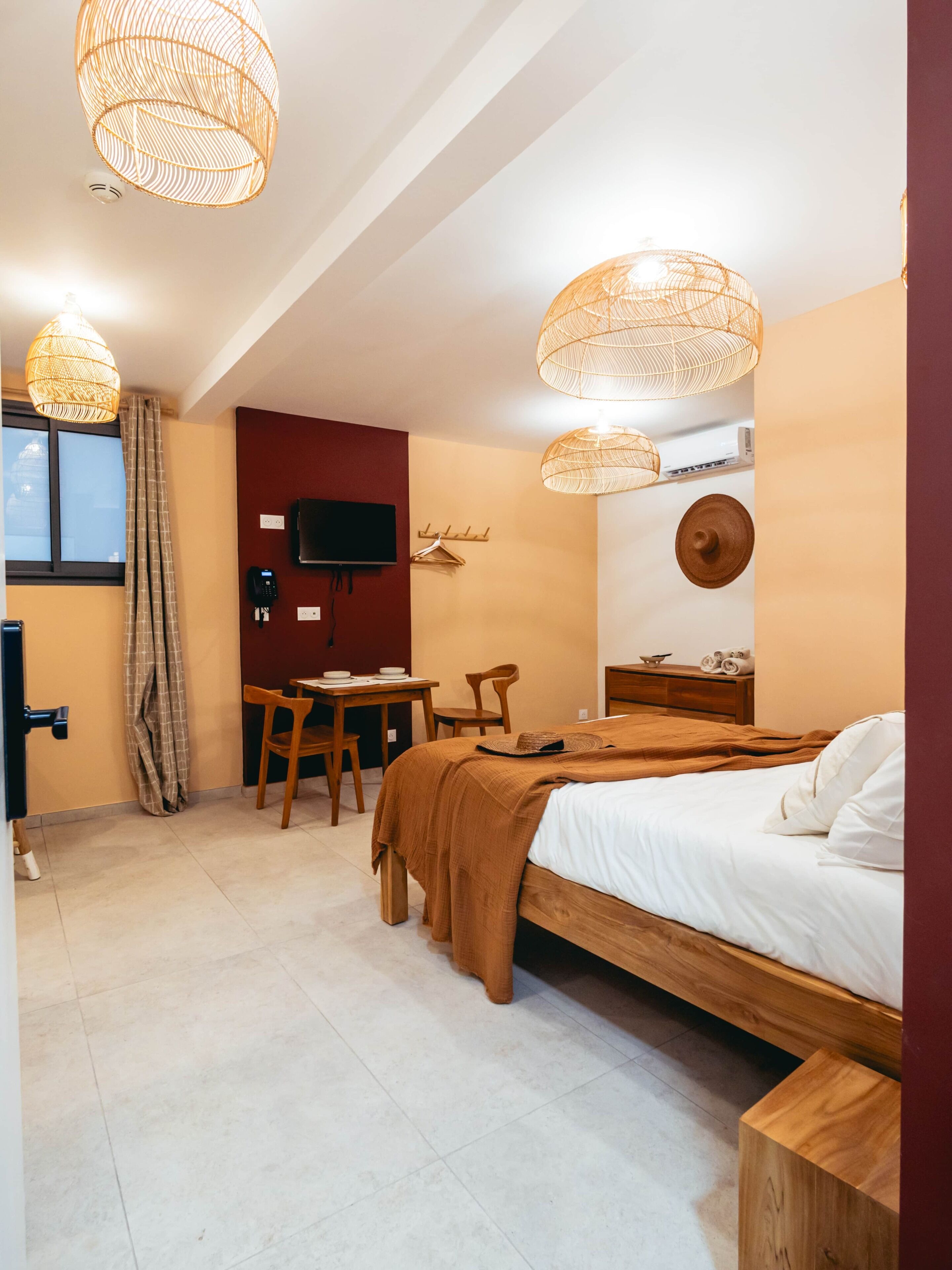 Une chambre d’hôtel équipée d’un lit, d’un bureau, d’une chaise, d’une télévision et d’un téléphone fixé au mur.