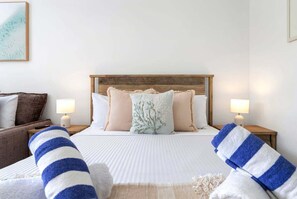 A hotel room with a bed, two bedside lamps, a headboard, and a view of the room's interior. - Belle Escapes 22 Rydges Plaza Esplanade with Garden Views (Cairns)