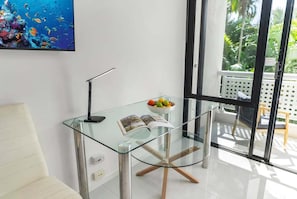 A modern room with a glass table, a bowl of fruit, and a magazine. - 22 Rydges Plaza Esplanade with Garden Views (Cairns)