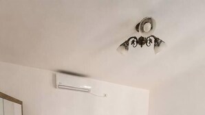 A bedroom with a bed, bedside tables, a mirror, and an air conditioning unit. - Elegant Urban Retreat | Near Old Town (Bucharest)
