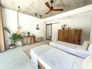 A bedroom with a bed, bedside tables, a wardrobe, a desk, and a ceiling fan. - Kima Surf Camp Hiriketiya (Maaliyadda)