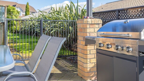 An outdoor grill area with a metal grill, a brick chimney, and a metal chair. - Great Short-Mid Term Stay! River Views & Games Room (Hamilton)