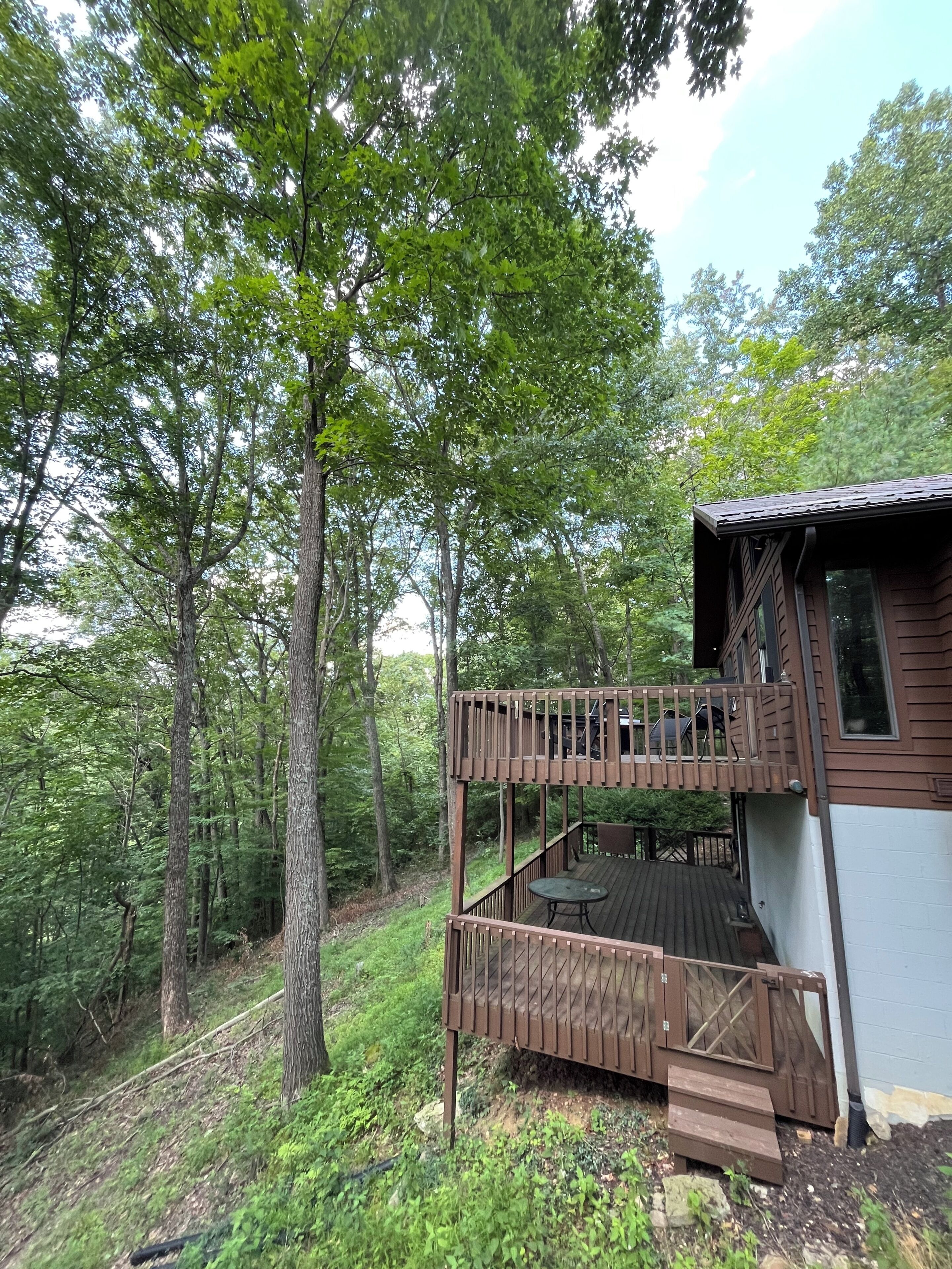 Une cabane dotée d’une terrasse en bois, d’une petite table et d’un banc.