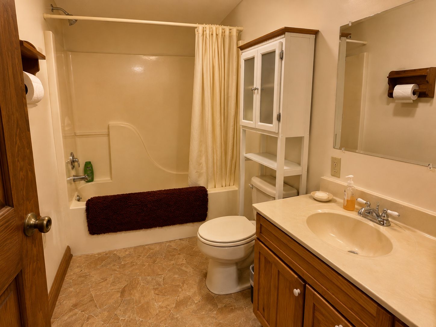 Une salle de bain avec une baignoire, des toilettes, un meuble-lavabo et un miroir.