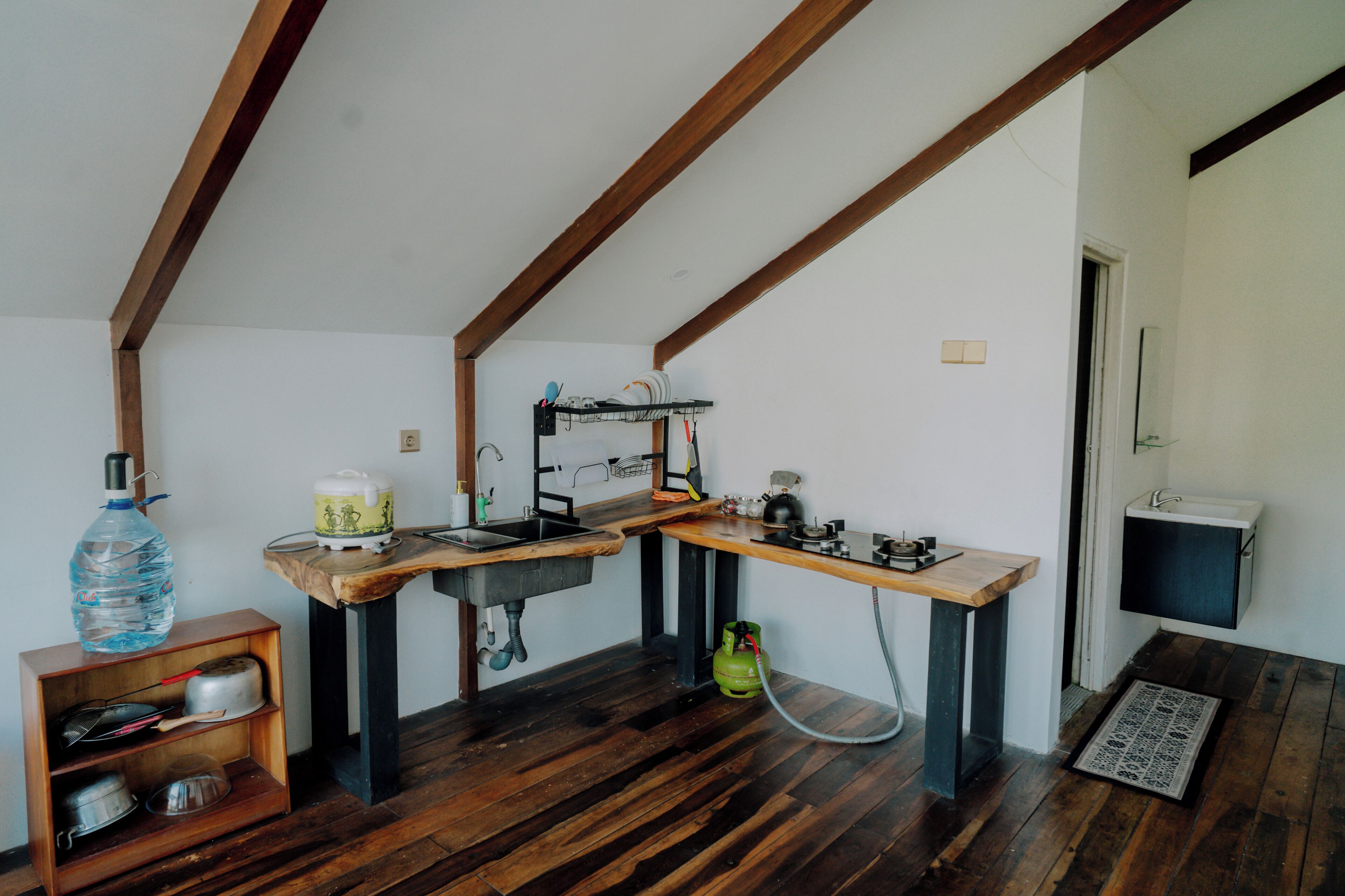 A compact kitchen with a wooden countertop, a sink, and a gas stove.