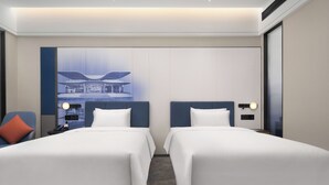 Habitación de hotel con dos camas, un ventanal grande y una obra de arte colgada en la pared.
