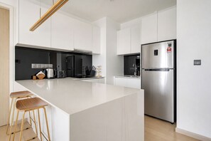 Eine moderne Küche mit Kochinsel, Edelstahlgeräten und minimalistischem Design.