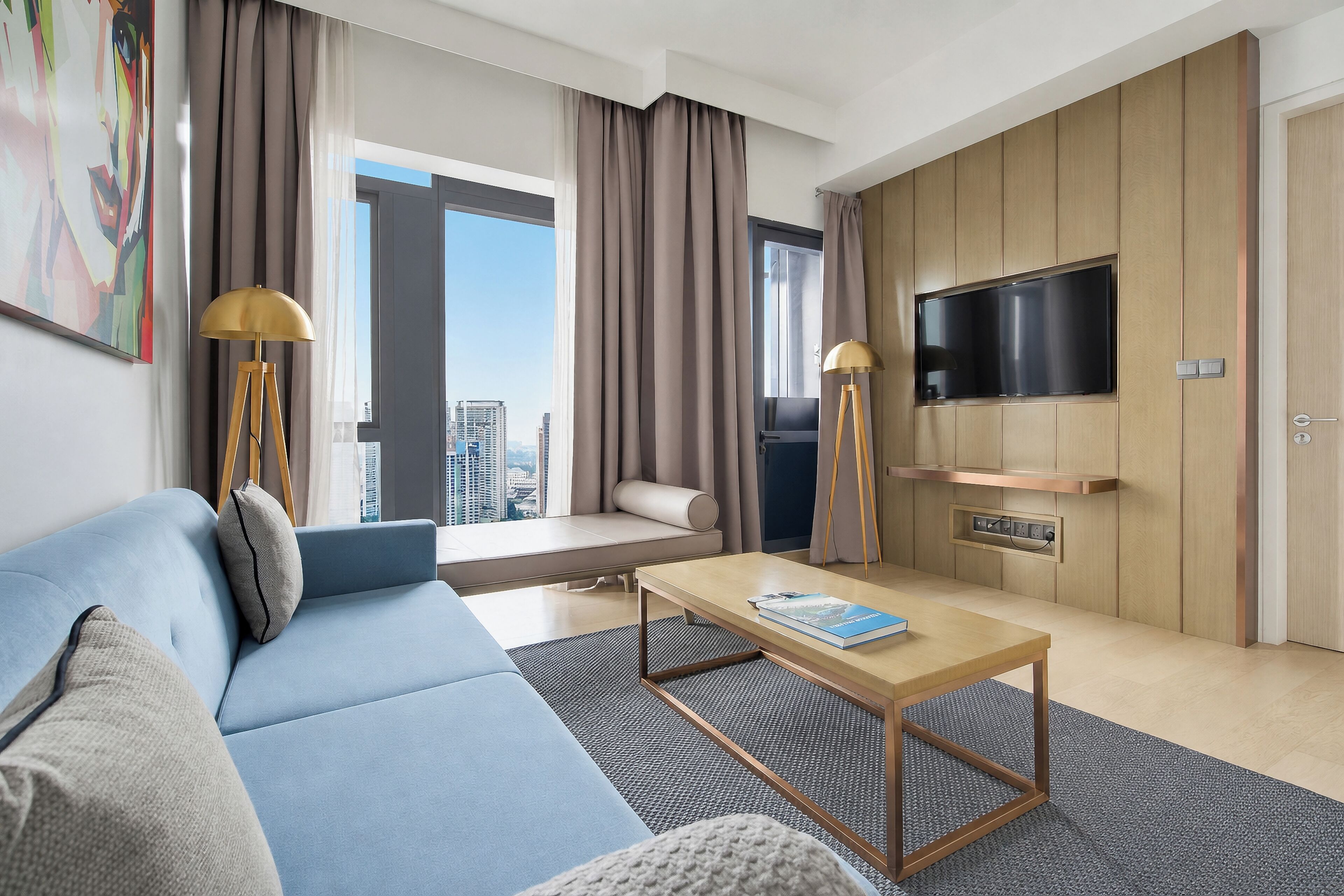Une chambre d’hôtel moderne avec un canapé, une table basse, une télévision et une vue sur la ville.