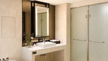 A modern bathroom with a freestanding bathtub, a vanity with a mirror, and a walk-in shower.