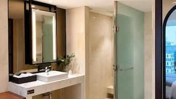Un baño moderno con un espejo grande, dos lavamanos y una zona de ducha.