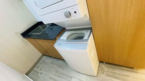 A compact laundry area with a front-loading washing machine and a dryer. - Modern Luxury Apartment in Baní (Baní)