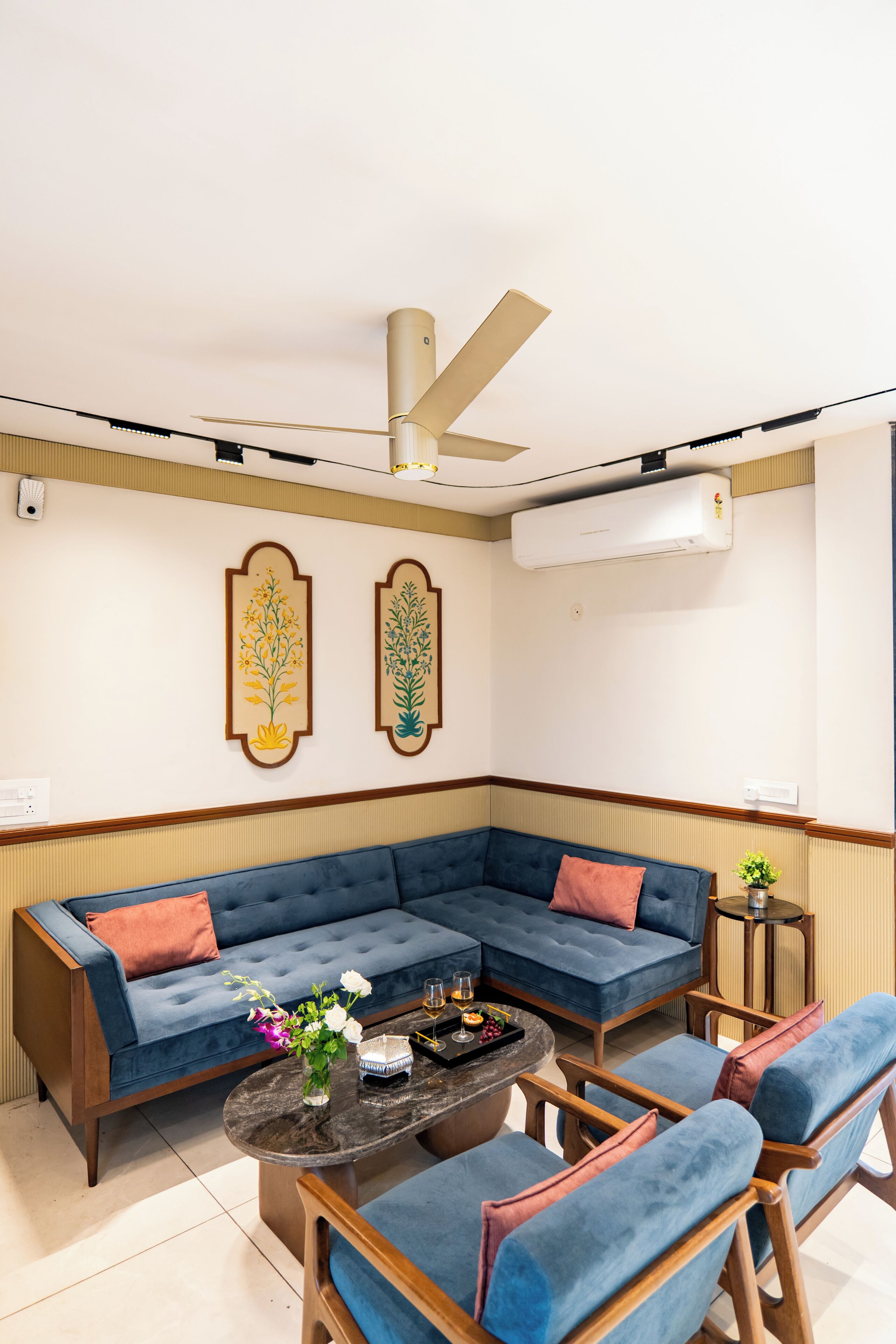 Un salon moderne avec un canapé d’angle, une table basse et deux fauteuils.