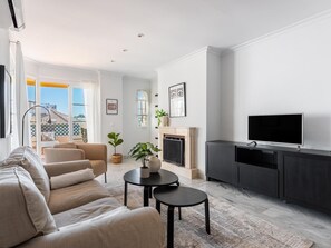 A modern living room with a sofa, a fireplace, a television, and a view of the outside. - Se or o de Aloha in Marbella (Marbella)