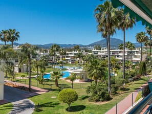 A resort with a pool, palm trees, and a mountain in the background. - Locrimar Family Apartment With Amazing Location (Marbella)