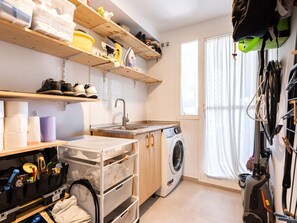 A compact kitchen with a washing machine, a sink, and storage shelves. - Locrimar Family Apartment With Amazing Location (Marbella)