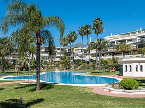 A resort with a large swimming pool surrounded by palm trees and a mountain in the background. - Locrimar Family Apartment With Amazing Location (Marbella)