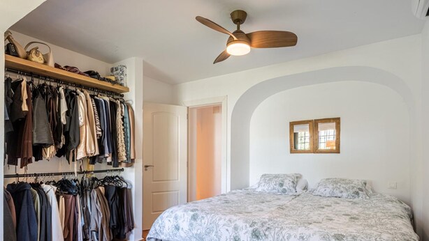 A bedroom with a bed, a ceiling fan, a wardrobe, and a door. - Villa Amapolas 222 in Marbella (Marbella)