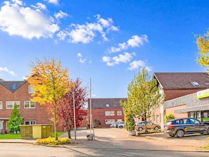A residential street with houses, parked cars, and autumn trees. - Meeresrauschen by Interhome (Burhave)