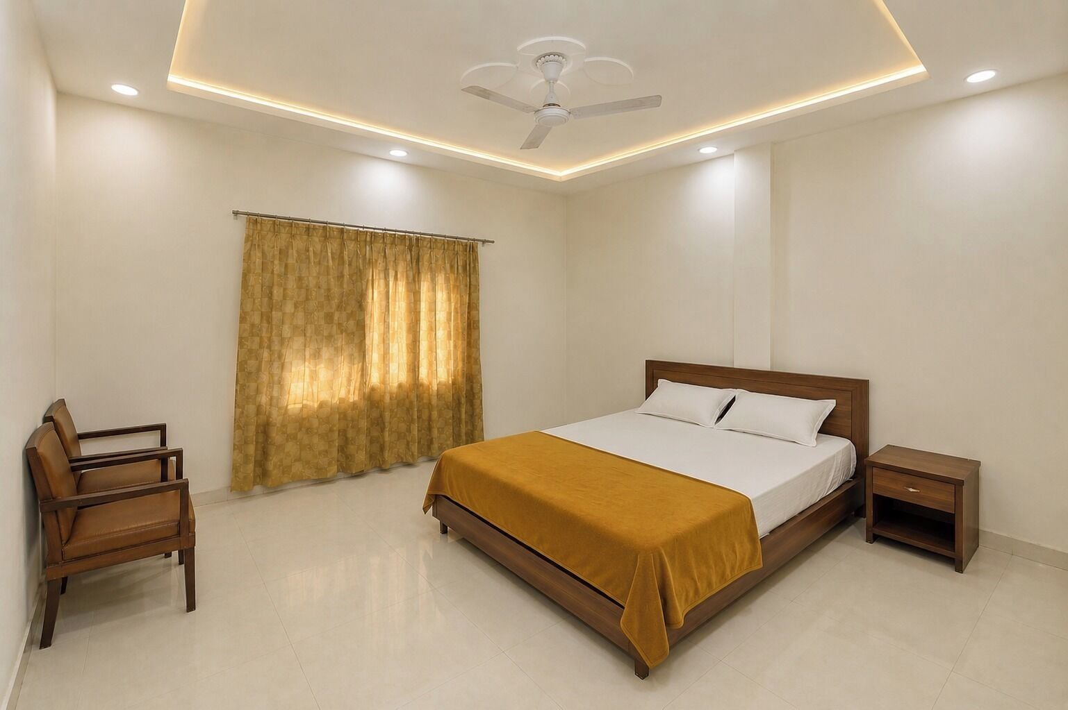 A bedroom with a bed, a chair, a nightstand, a ceiling fan, and a window with curtains.