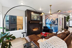 Un salon moderne avec une cheminée, un canapé en cuir et une grande fenêtre.