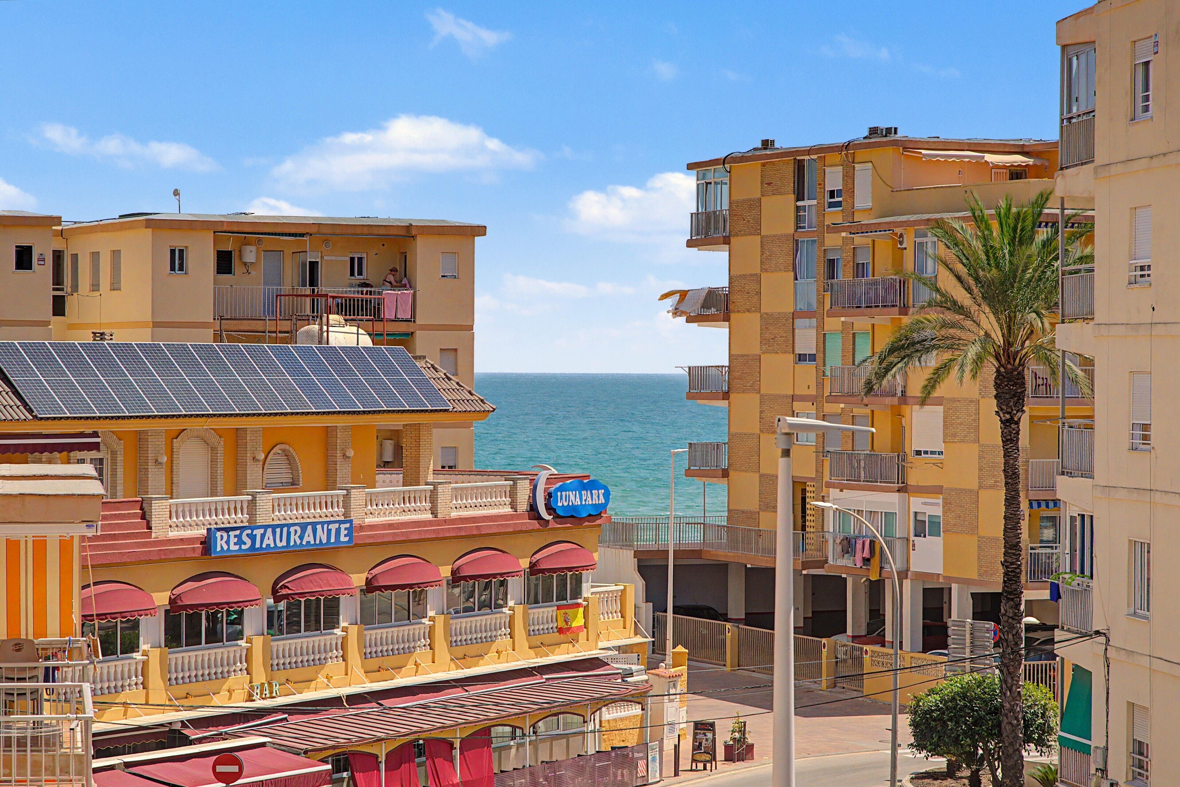 Ein Küstengebäude mit Restaurant und Bar, Balkonen und Blick aufs Meer.