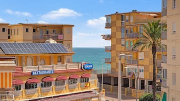 Ein Küstengebäude mit Restaurant und Bar, Balkonen und Blick aufs Meer.
