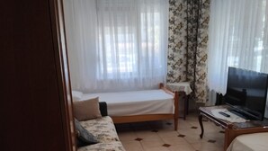Et hotelværelse med seng, sofa, fjernsyn og et lille bord.
