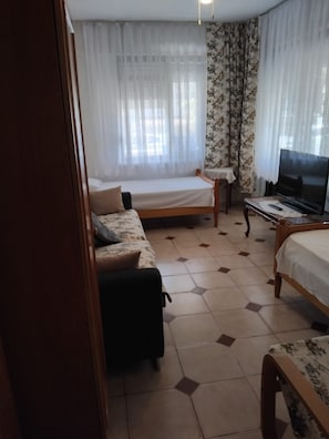 Ein Hotelzimmer mit Bett, Sofa, Fernseher und kleinem Tisch.