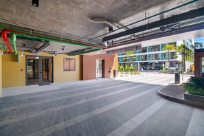 An indoor area with a tiled floor, a door leading to a room, and a view of a building with a 'NO ENTRY' sign. - Seashore Residences, Three-Bedroom 3B Deluxe (Thalang)