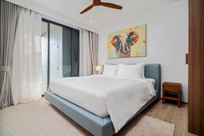 Ein modernes Schlafzimmer mit einem großen Bett, einem Deckenventilator, einem Elefantenbild und einer Schiebetür.