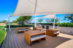 An outdoor patio with wooden furniture, a white canopy, and a view of the surrounding landscape. - Seashore Residences, Three-Bedroom 3A Premium (Thalang)