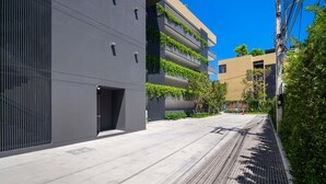 A modern building with a grey facade, vertical garden balconies, and a paved walkway. - Seashore Residences, Three-Bedroom 3A Premium (Thalang)