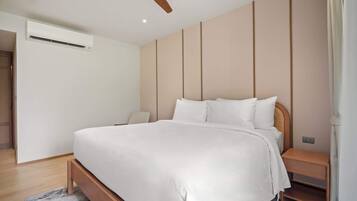 A modern bedroom with a bed, bedside table, and a ceiling fan.