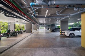 A multi-level parking garage with concrete floors and overhead pipes.