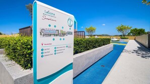 LaGuna Beach Residences -kyltti, jossa näkyy uima-allas ja kirkkaan sininen taivas.