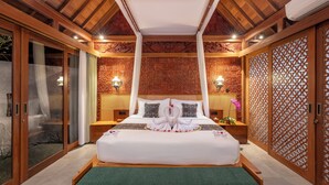 Amplia habitación con una cama grande, dosel y un adornado muro.