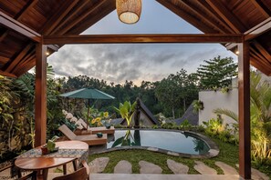 A covered outdoor area with a pool, lounge chairs, and a table. - Ananya Ubud Villa (Tegallalang)
