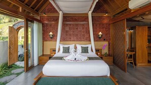 Una habitación con cama, dosel, mesita de noche, lámpara y vistas al exterior.