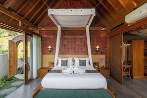 A room with a bed, a canopy, a nightstand, a lamp, and a view of the outdoors. - Ananya Ubud Villa (Tegallalang)